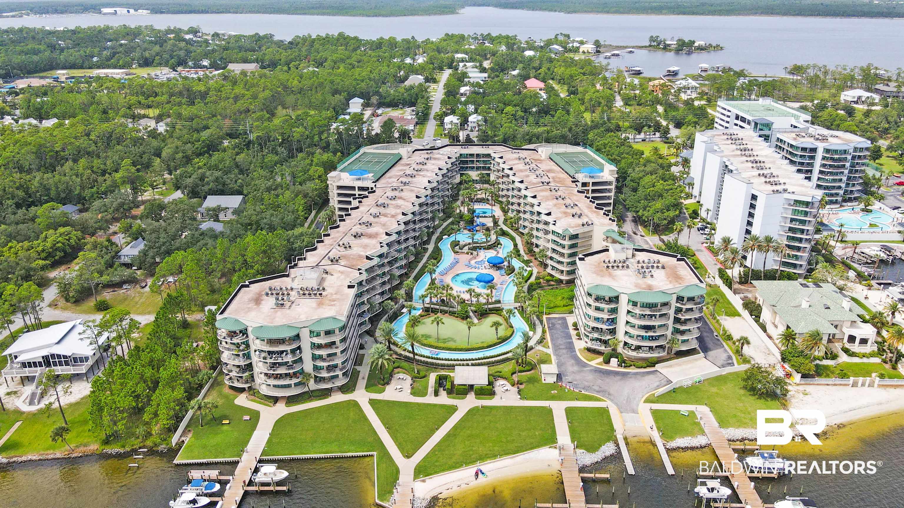 27580 Canal Road, Unit 1421 Orange Beach, AL 36561 - Photo 3 of 40 Extensive resort-style property featuring multiple buildings, lush green landscaping, and a large central water park with slides and multiple pools