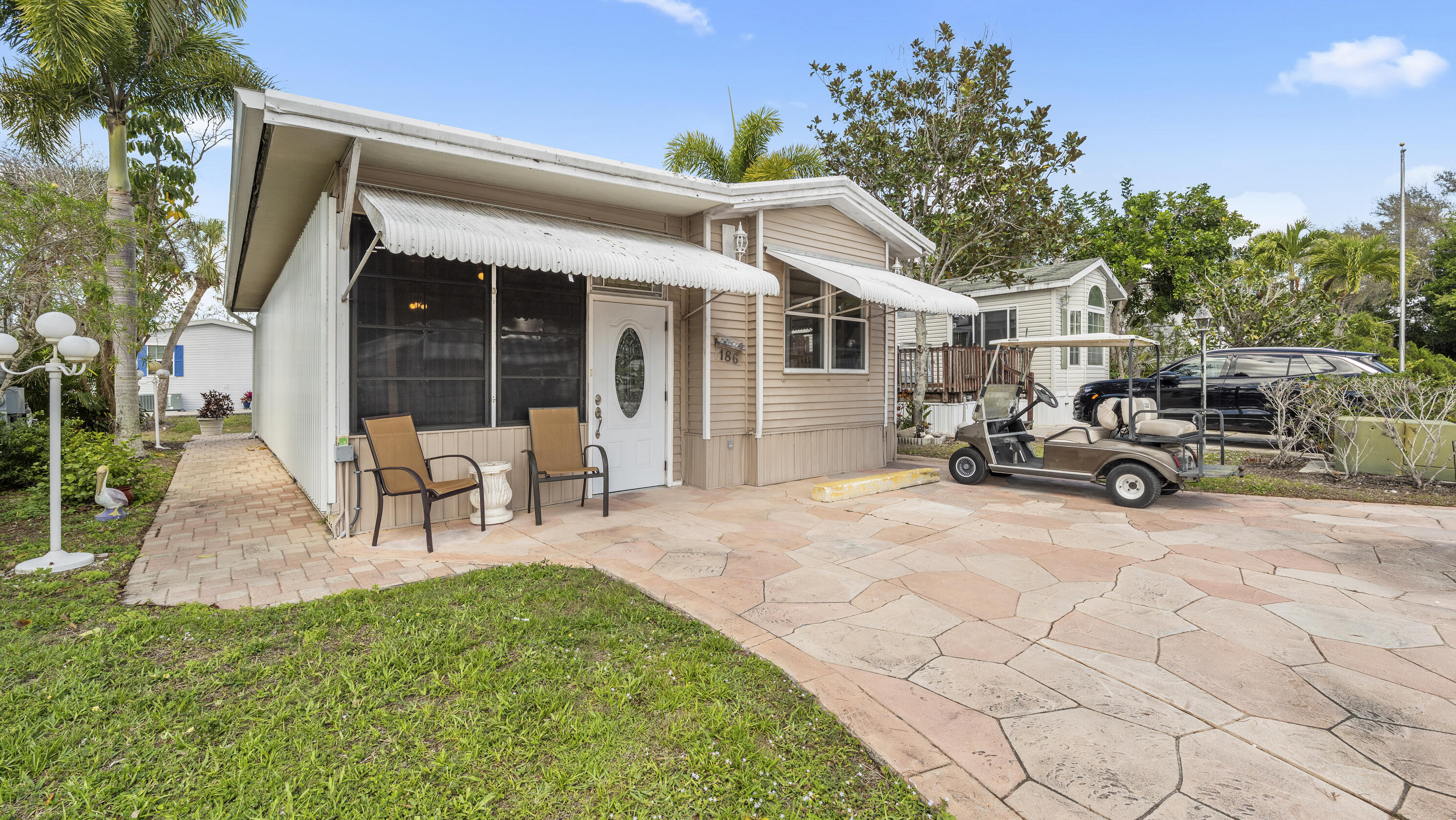 186 Panther Pass Circle Naples, FL 34114 - Photo 1 of 40 a view of a patio with table and chairs under an umbrella