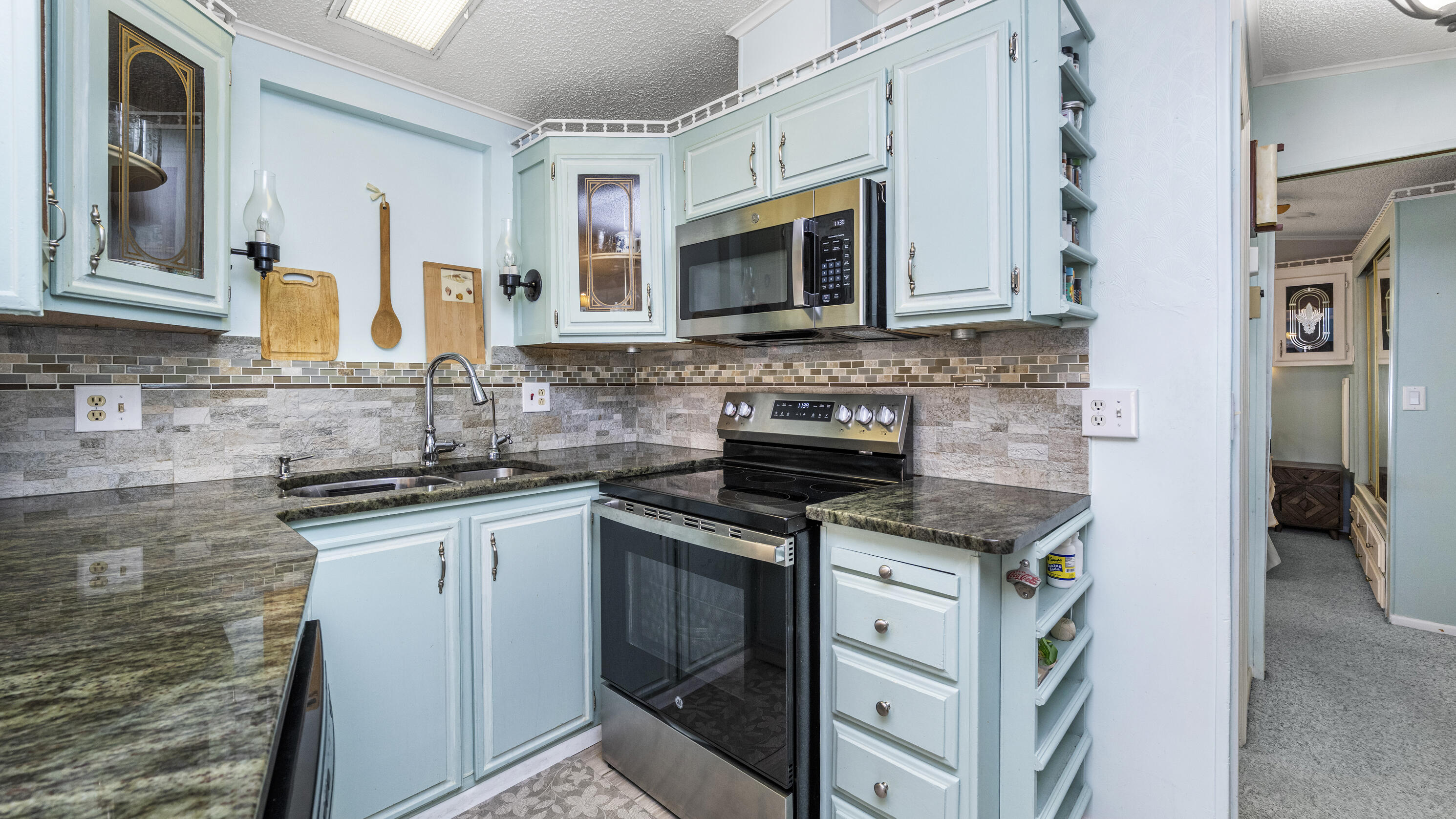 186 Panther Pass Circle Naples, FL 34114 - Photo 7 of 40 a kitchen with stainless steel appliances granite countertop a sink stove and microwave