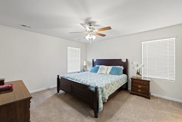 a bathroom with a granite countertop sink a toilet and a large mirror