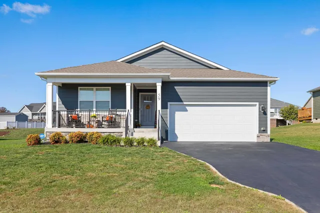 a front view of a house with garden and parking