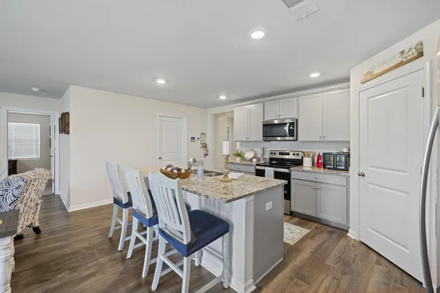 a kitchen with a table chairs refrigerator and microwave