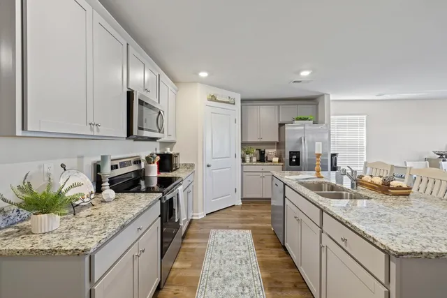 a kitchen with sink a counter top space cabinets and stainless steel appliances