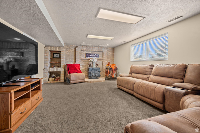 2298 West 800 North Clinton, UT 84015 - Photo 17 of 53 Living room with carpet flooring, brick wall, and a textured ceiling