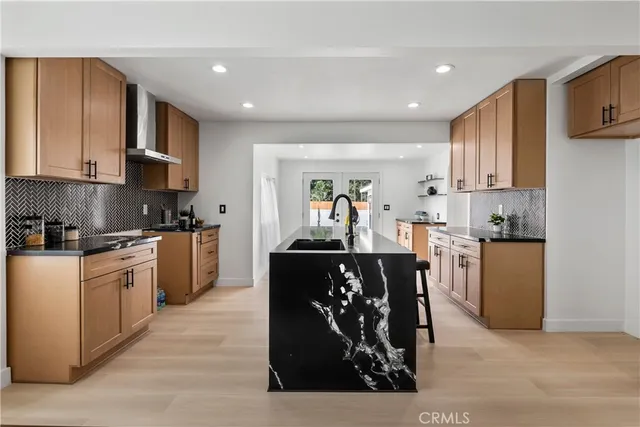 a kitchen with stainless steel appliances kitchen island granite countertop a refrigerator a stove top oven a sink and dishwasher