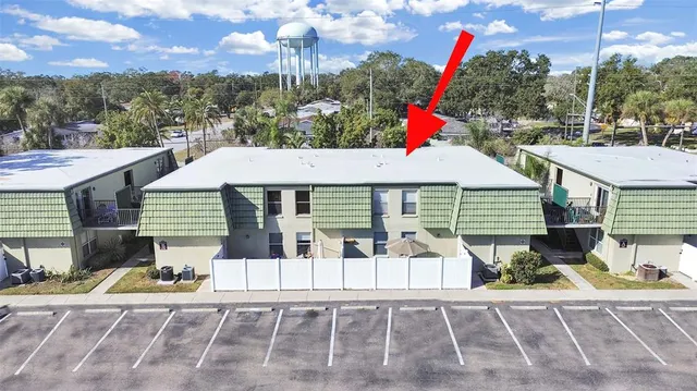 a view of a white house with a yard and potted plants