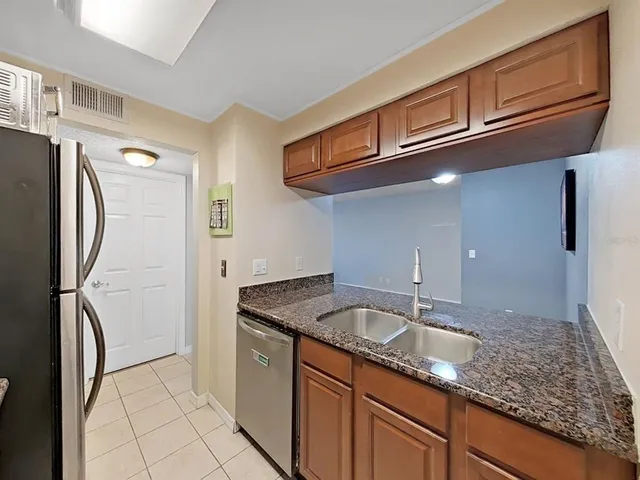 a kitchen with stainless steel appliances granite countertop a sink refrigerator and cabinets