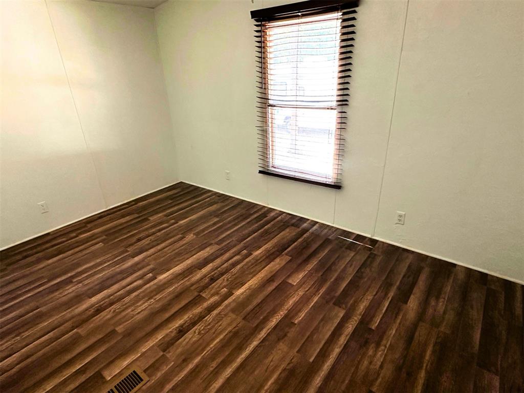 1395 Blackjack Road Valley View, TX 76272 - Photo 12 of 22 a view of a room with wooden floor and a window