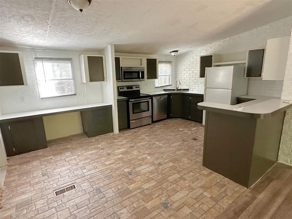 1395 Blackjack Road Valley View, TX 76272 - Photo 3 of 22 a large kitchen with cabinets wooden floor and stainless steel appliances