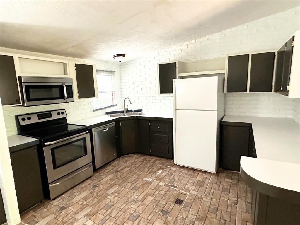 1395 Blackjack Road Valley View, TX 76272 - Photo 4 of 22 a kitchen with a sink a stove and a refrigerator