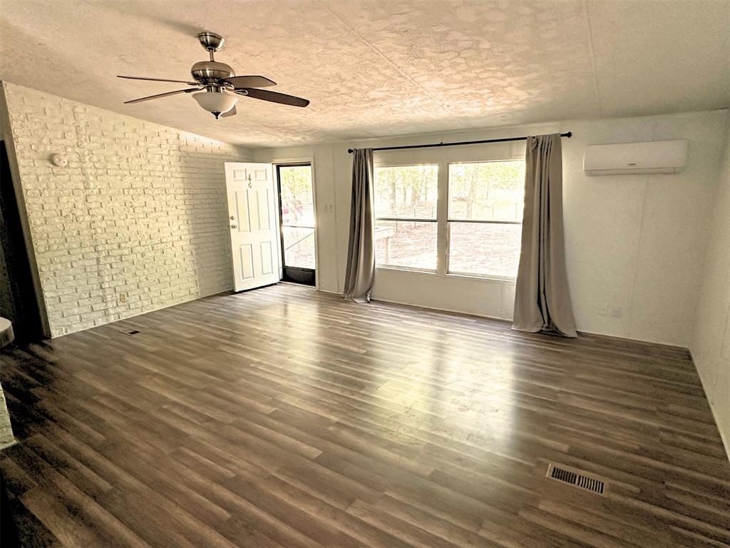 1395 Blackjack Road Valley View, TX 76272 - Photo 6 of 22 a view of an empty room with a window and wooden floor