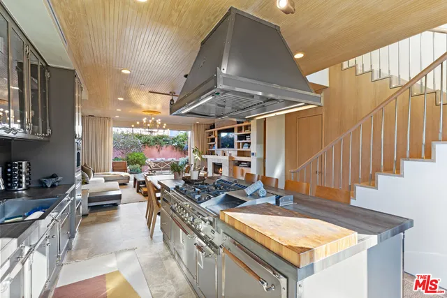 a kitchen with stainless steel appliances granite countertop a sink a stove and a wooden floors