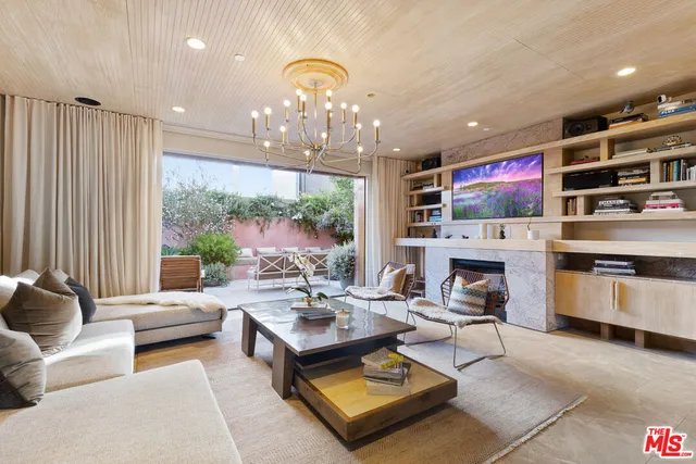 a living room with furniture a chandelier and a fireplace
