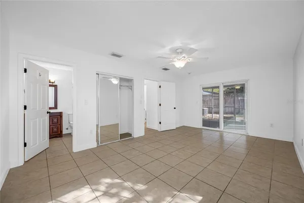 a view of an empty room with window and chandelier