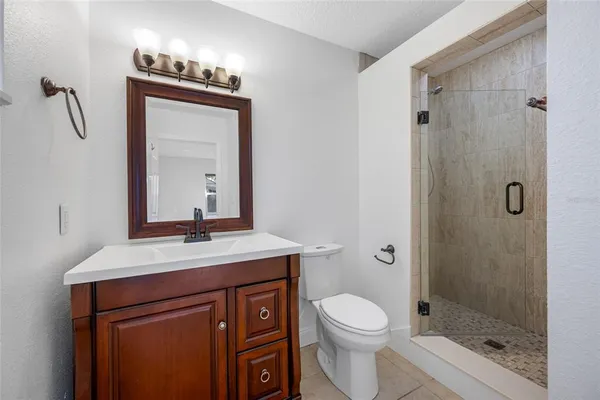a bathroom with a granite countertop sink toilet a mirror and shower