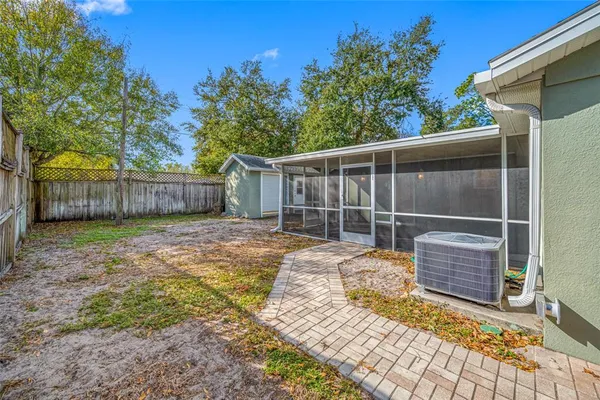a view of a backyard with a large tree and wooden fence