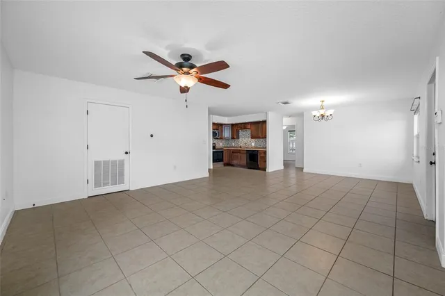 a view of empty room with a kitchen