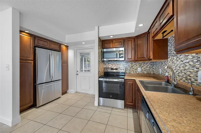 a kitchen with granite countertop a refrigerator and a sink