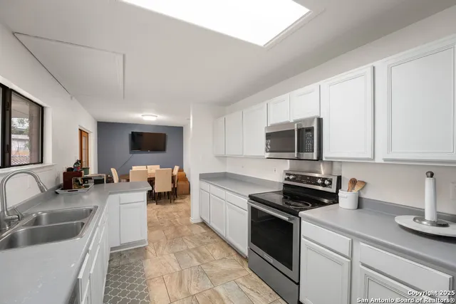 a kitchen with stainless steel appliances a stove a sink a microwave and cabinets