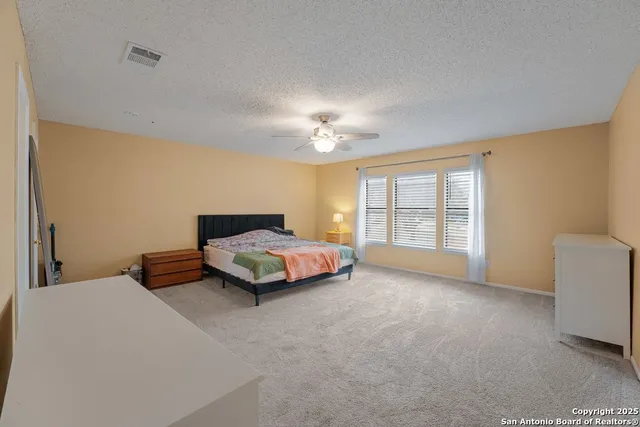 a spacious bedroom with a bed and a chandelier