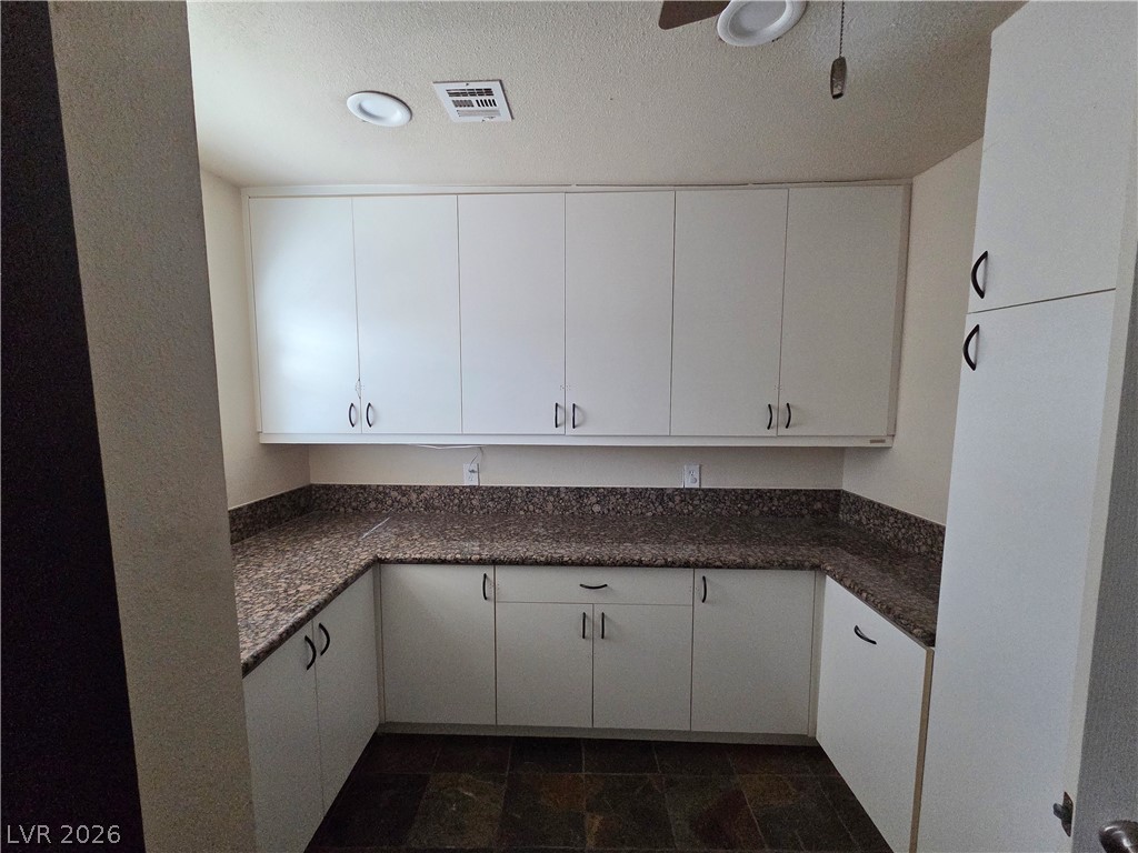 3381 Westwind Road Las Vegas, NV 89146 - Photo 34 of 52 Functional utility room with ample white cabinetry and durable countertops, perfect for storage and tasks.