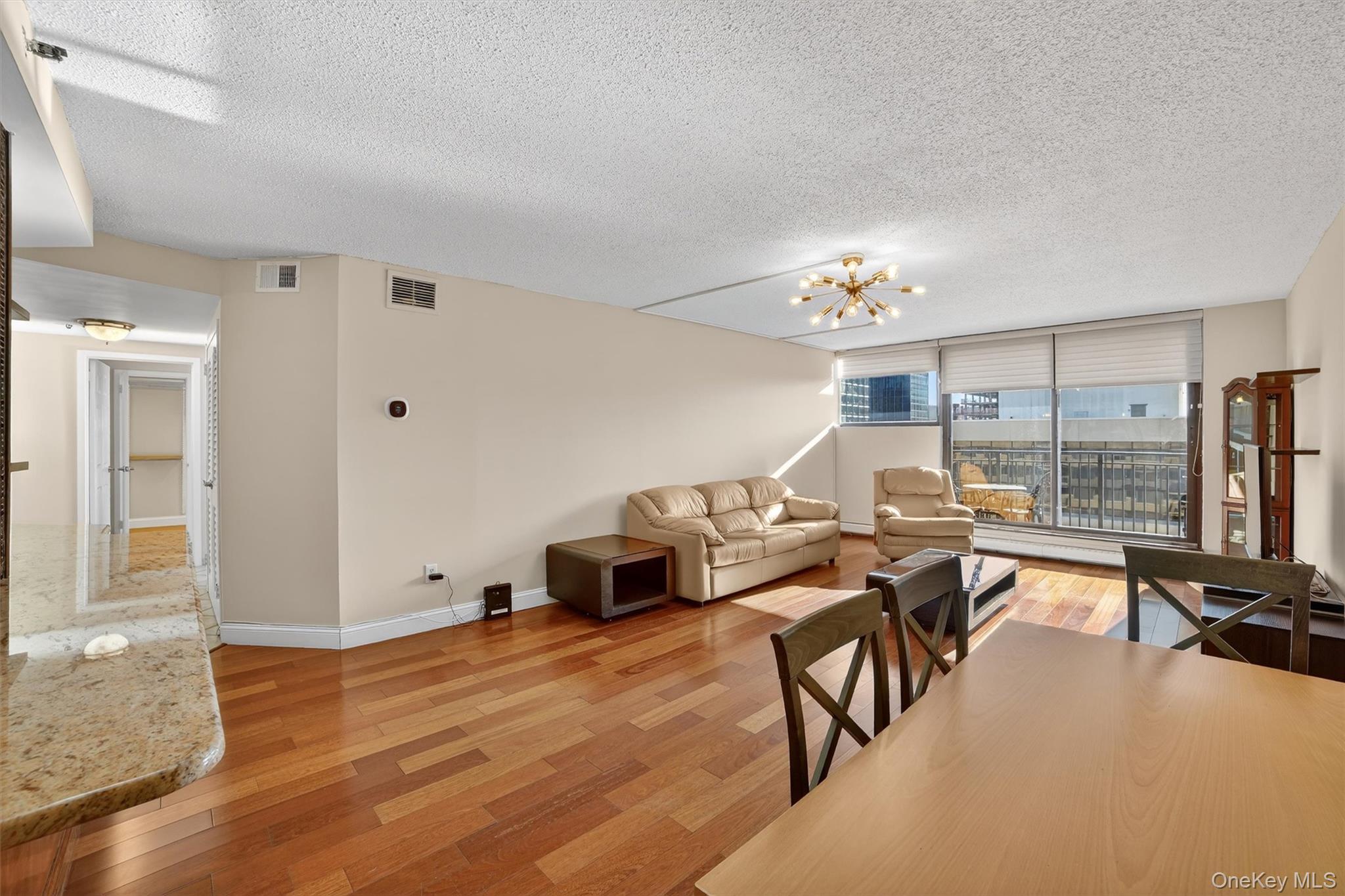 25 Rockledge Avenue, Unit 606 White Plains, NY 10601 - Photo 12 of 43 a living room with furniture and a chandelier