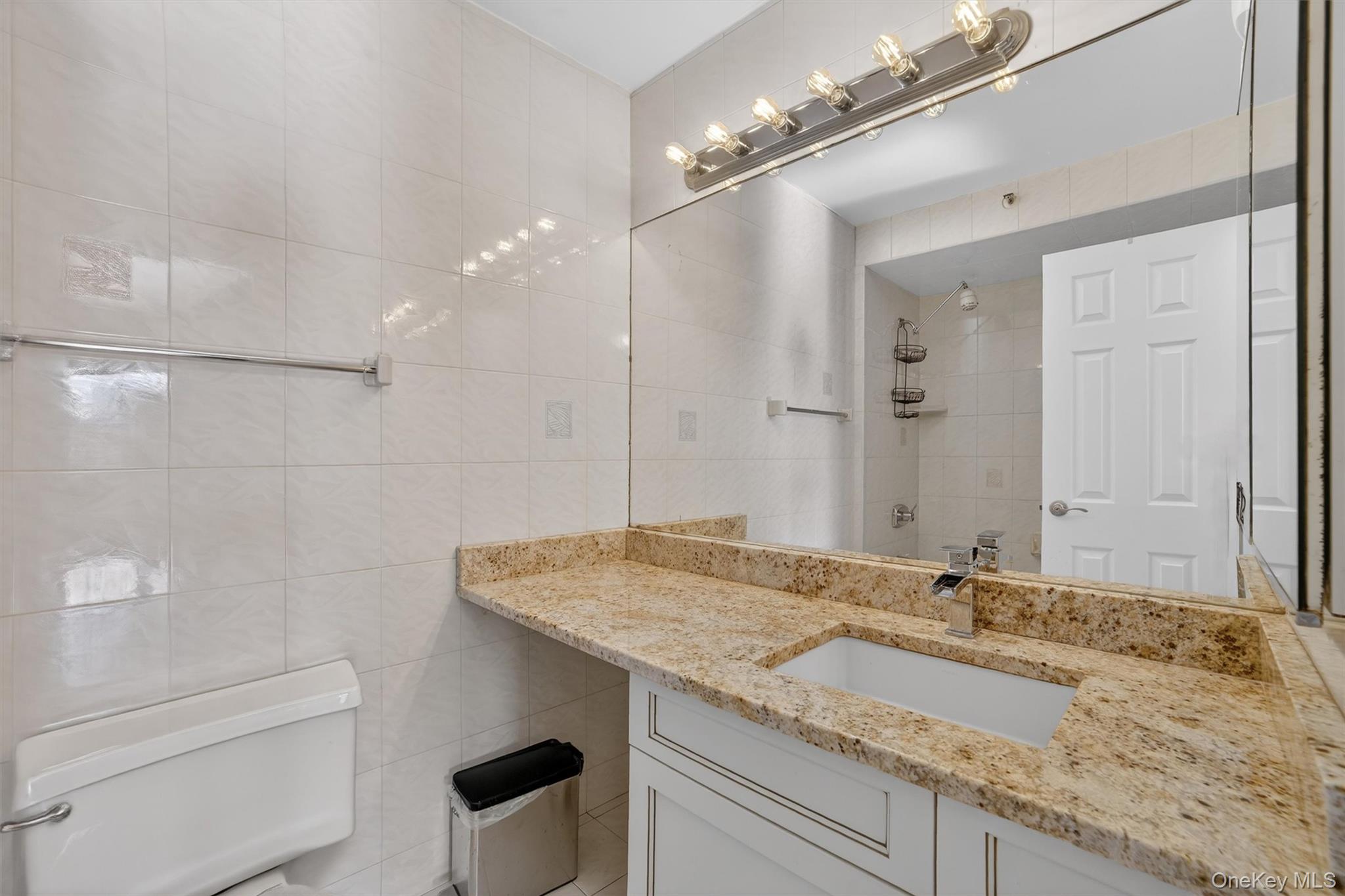 25 Rockledge Avenue, Unit 606 White Plains, NY 10601 - Photo 19 of 43 a bathroom with a granite countertop sink a toilet and shower