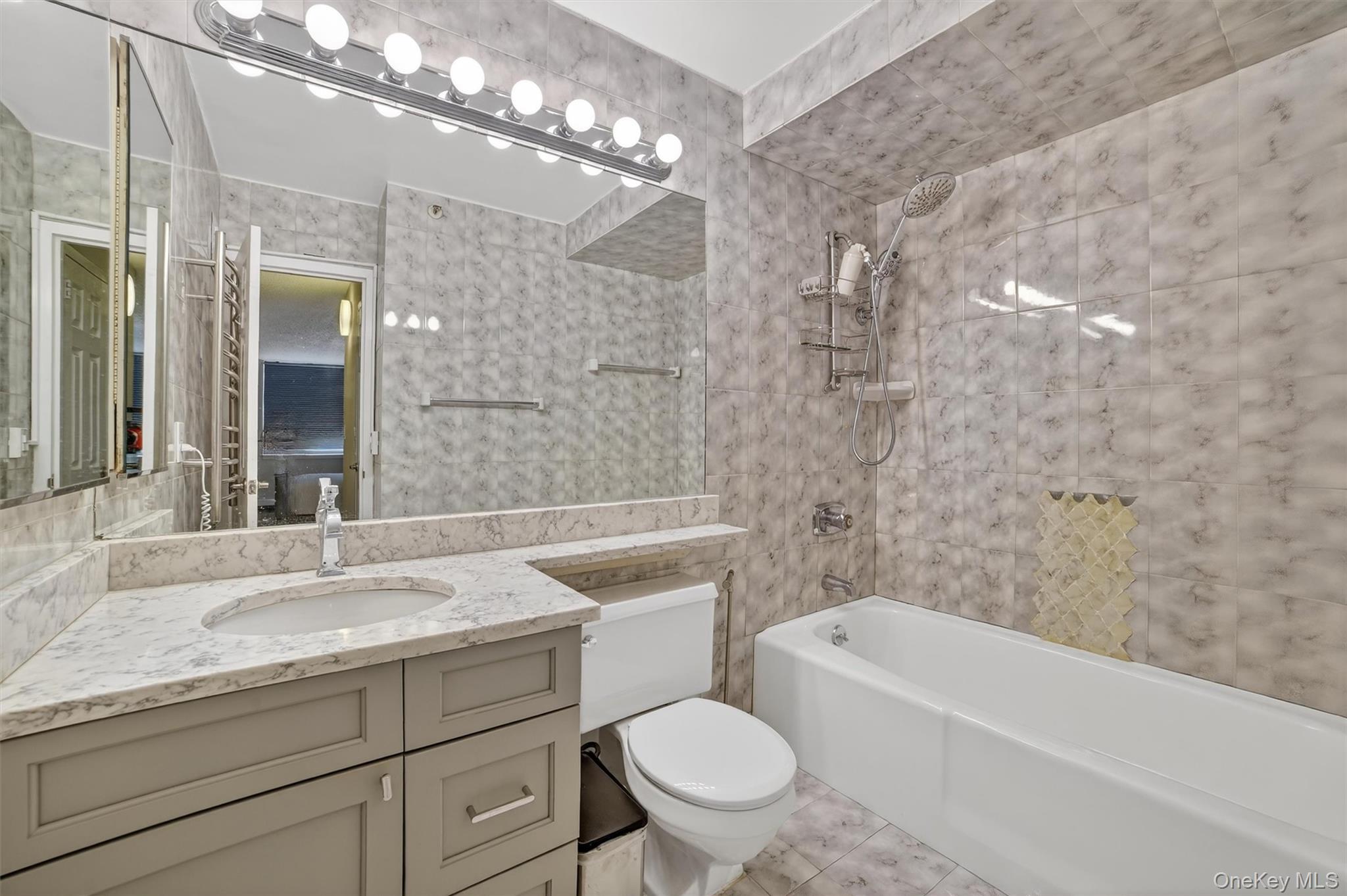 25 Rockledge Avenue, Unit 606 White Plains, NY 10601 - Photo 25 of 43 a bathroom with a granite countertop sink a toilet and bathtub