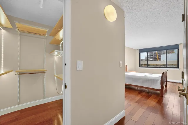 a bedroom with a bed windows and wooden floor