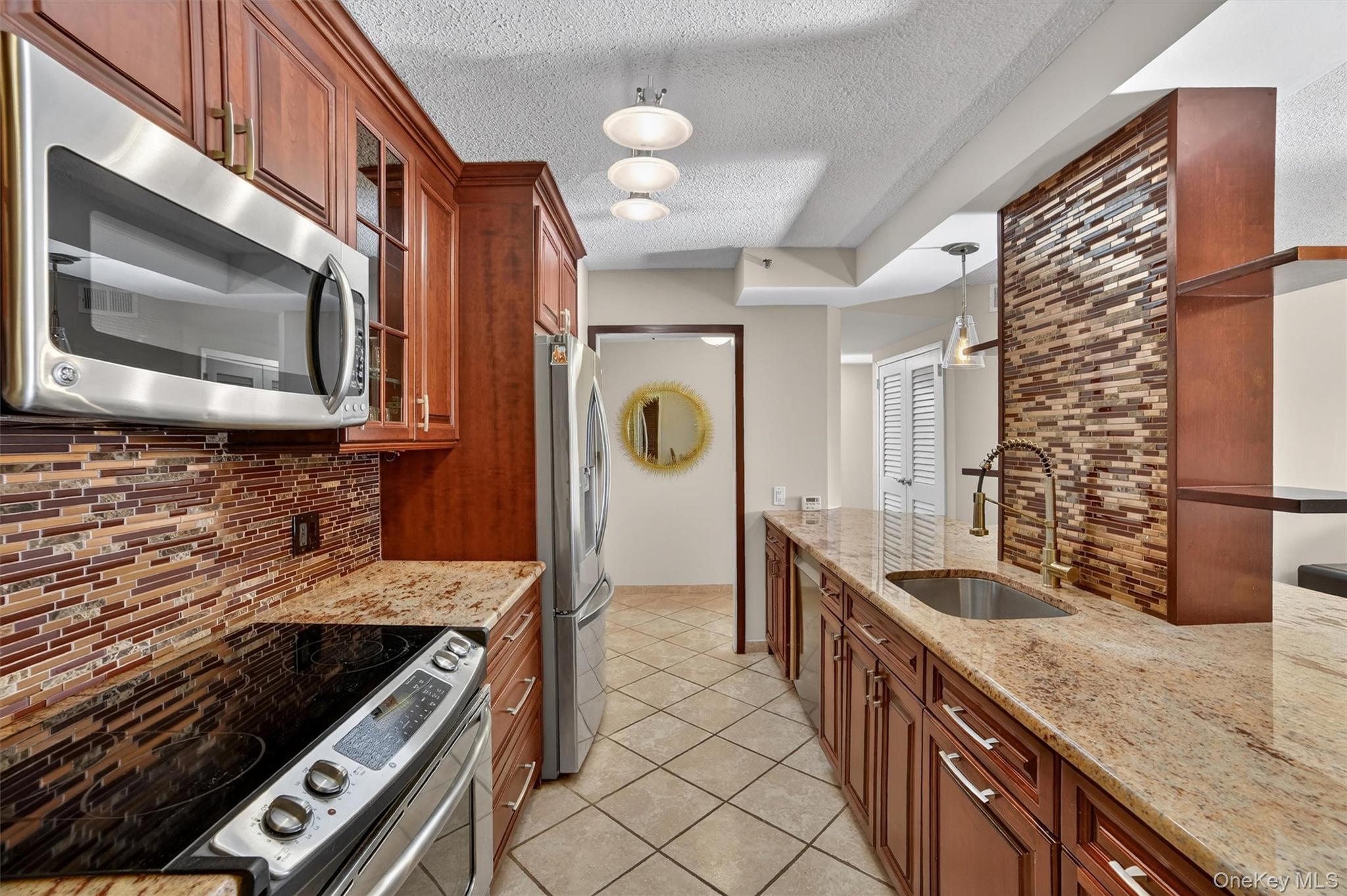 25 Rockledge Avenue, Unit 606 White Plains, NY 10601 - Photo 7 of 43 a kitchen with stainless steel appliances granite countertop a stove and a sink