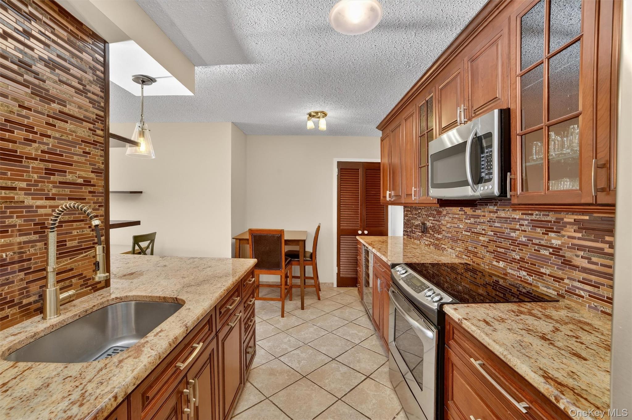 25 Rockledge Avenue, Unit 606 White Plains, NY 10601 - Photo 8 of 43 a kitchen with stainless steel appliances granite countertop a sink and a stove