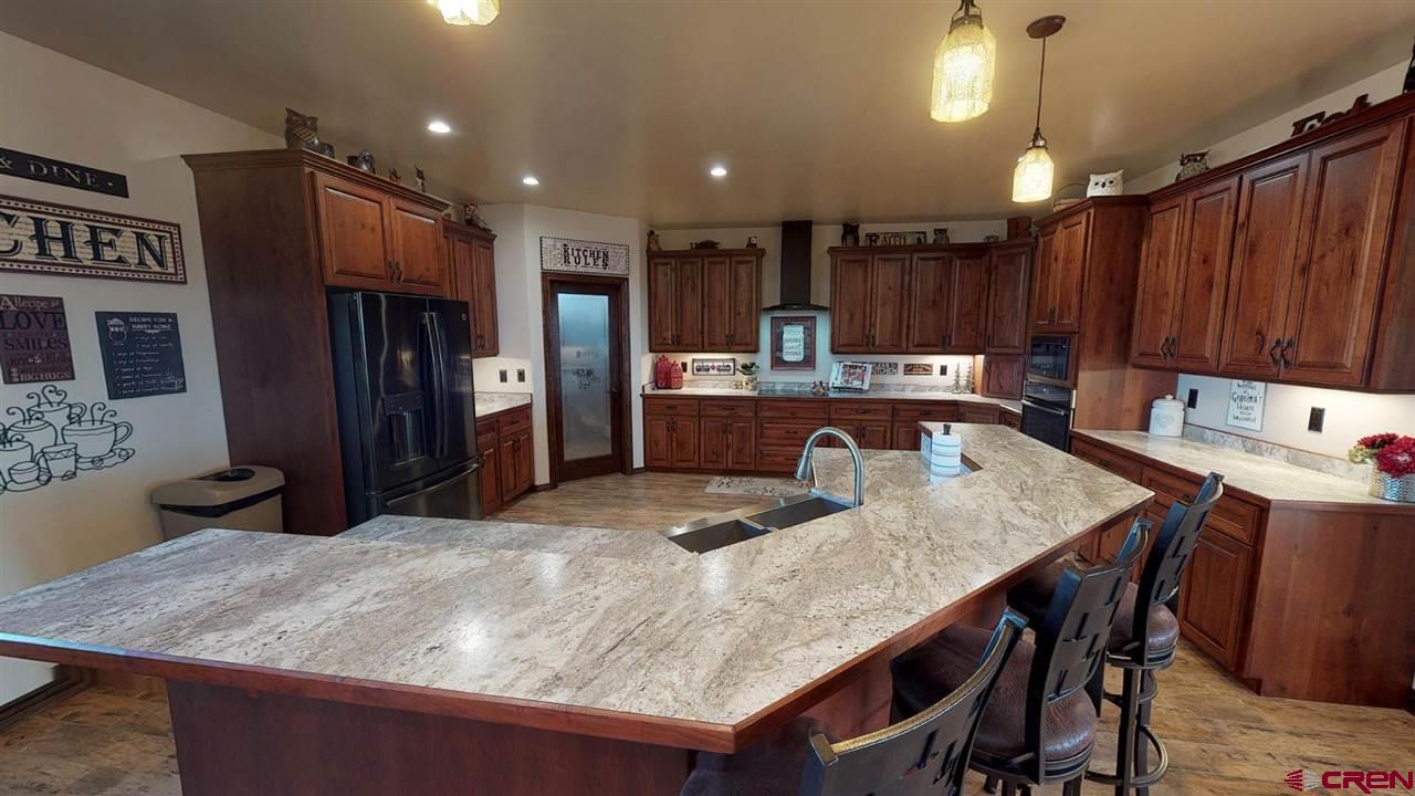 8370 2000th Road Austin, CO 81410 - Photo 16 of 35 a kitchen with a table chairs refrigerator and microwave