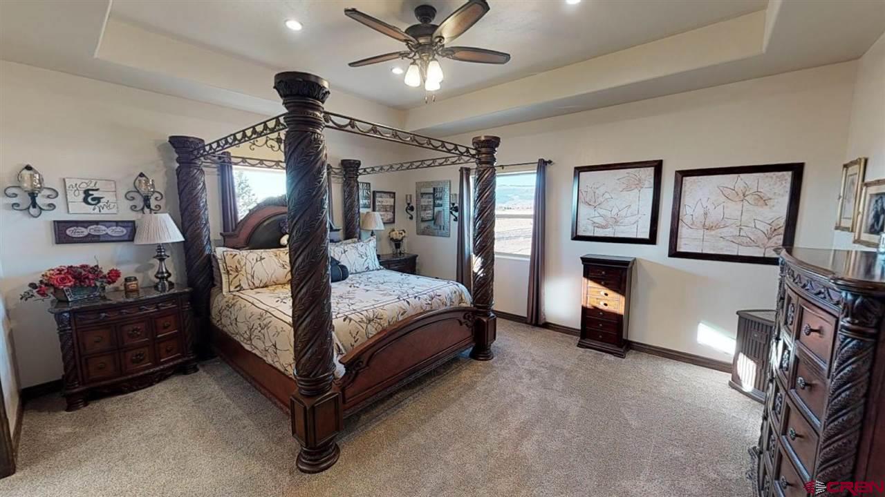 8370 2000th Road Austin, CO 81410 - Photo 18 of 35 a bedroom with a bed and a chandelier