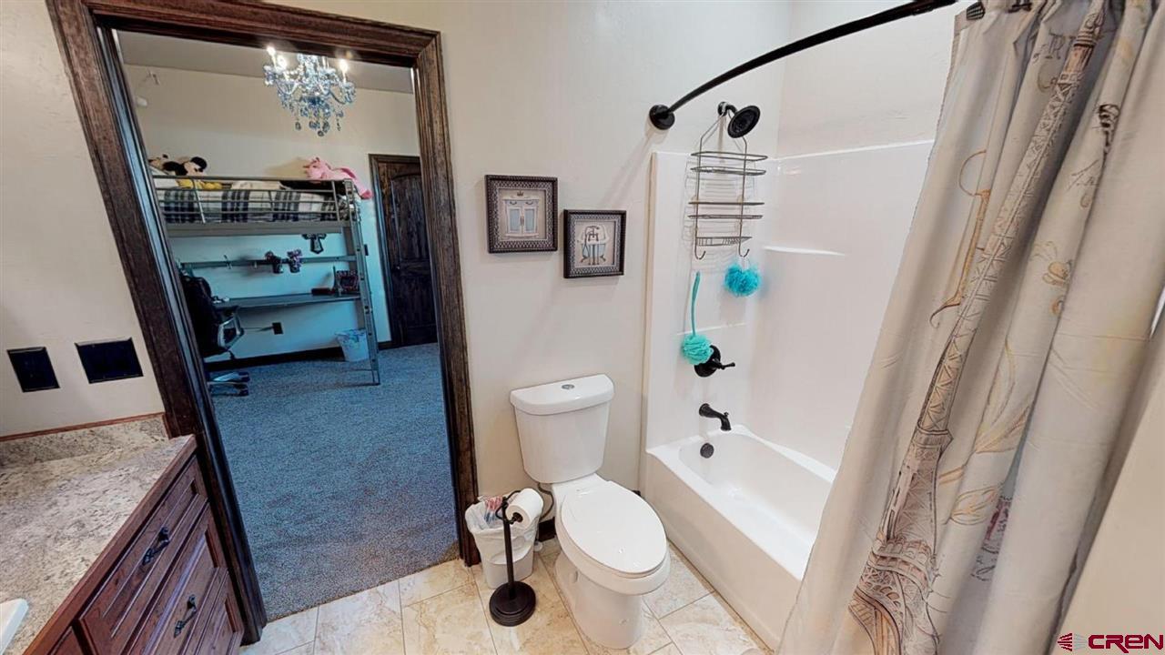 8370 2000th Road Austin, CO 81410 - Photo 27 of 35 a bathroom with a granite countertop sink a mirror a toilet and a shower