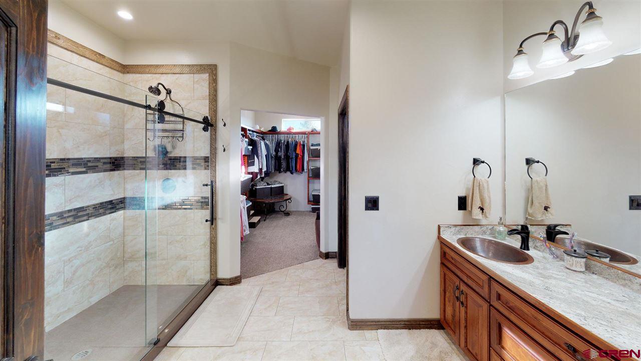 8370 2000th Road Austin, CO 81410 - Photo 28 of 35 a bathroom with a granite countertop sink a mirror and shower