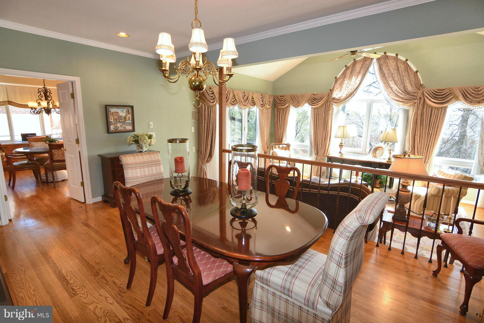 1040 South River Landing Road, Unit 1040 Edgewater, MD 21037 - Photo 11 of 30 a dining room with wooden floor a chandelier a wooden table and chairs