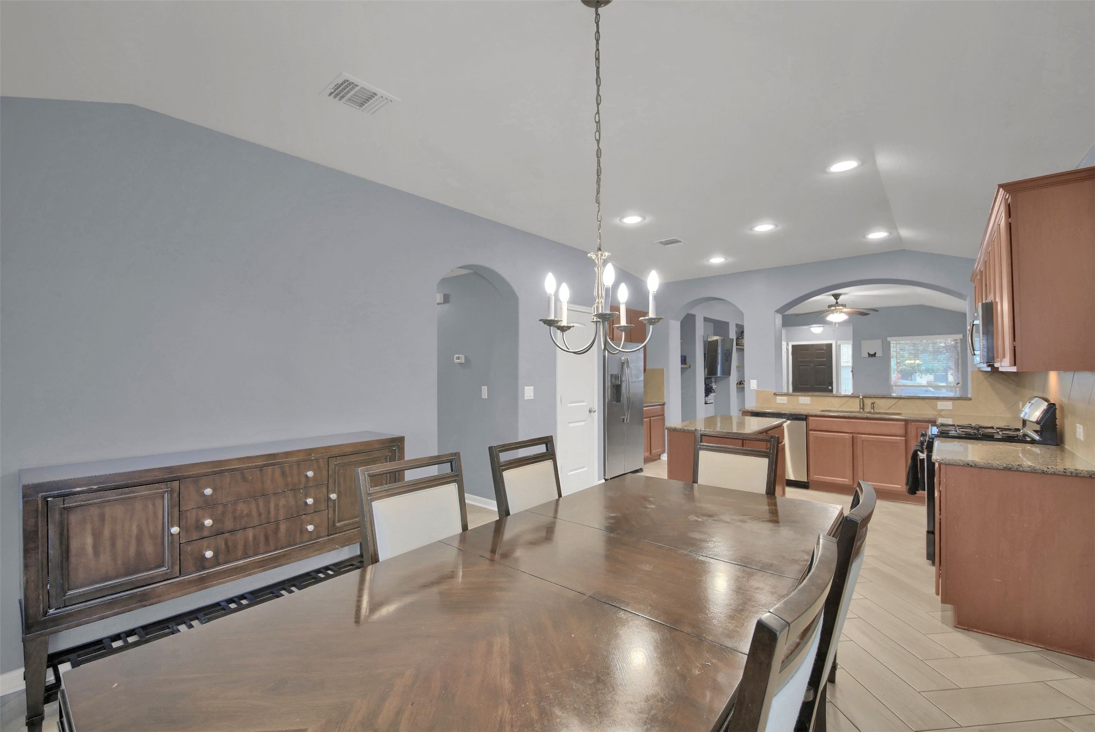 18005 Moreto Loop Pflugerville, TX 78660 - Photo 13 of 25 Dining space featuring a chandelier, vaulted ceiling, arched walkways, recessed lighting, and a ceiling fan