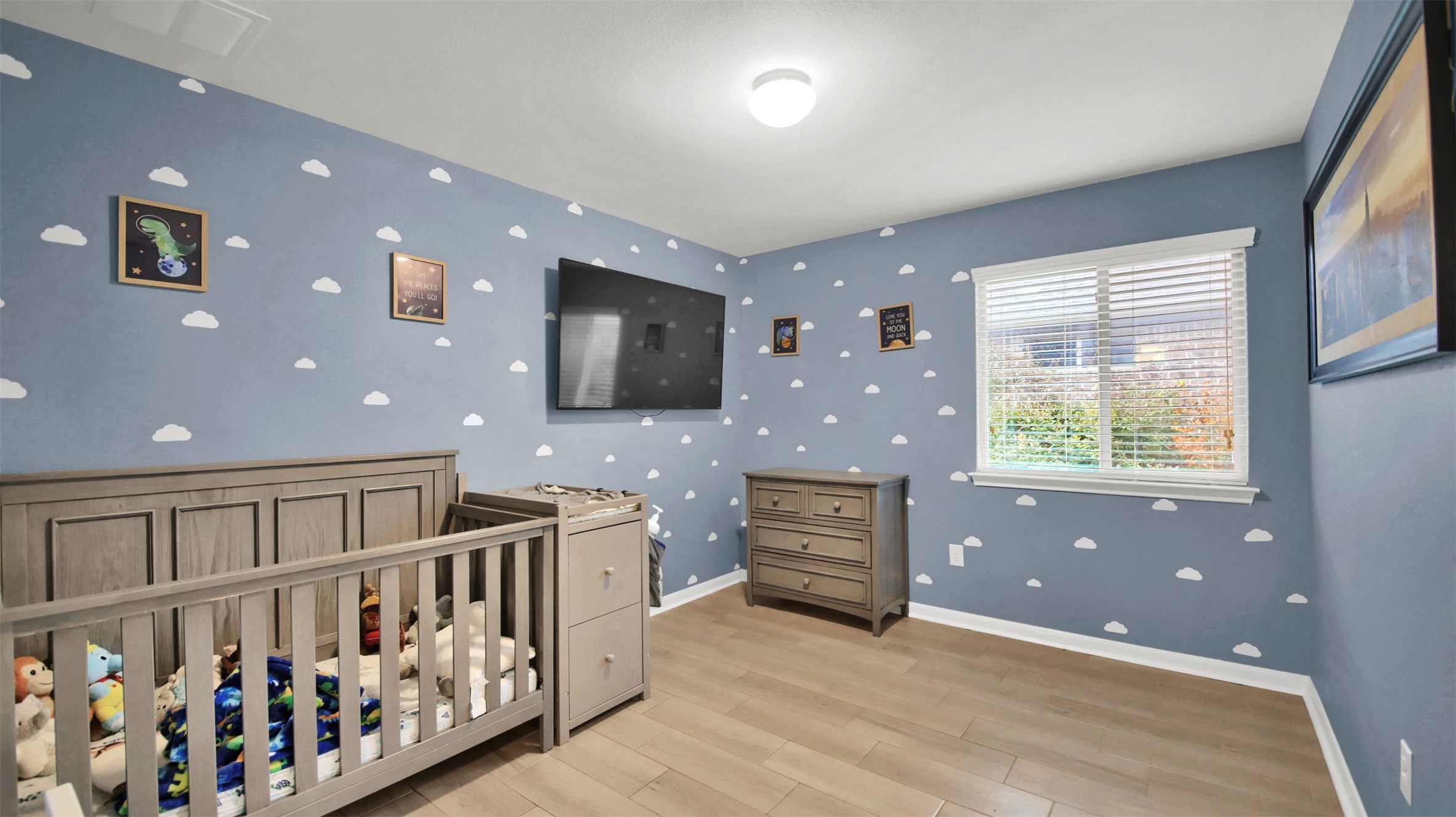 18005 Moreto Loop Pflugerville, TX 78660 - Photo 18 of 25 Bedroom with light wood-style flooring and a nursery area