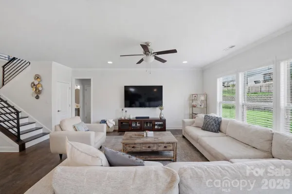 a living room with furniture flat screen tv and a window