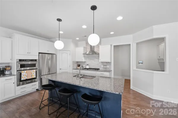a kitchen with refrigerator cabinets and wooden floor
