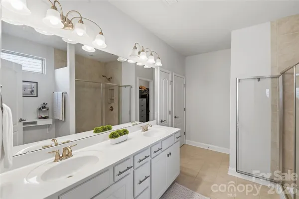 a bathroom with a double vanity sink mirror and shower