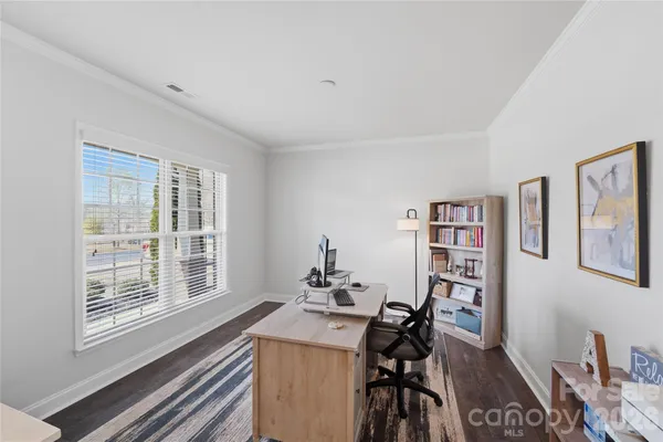 a view of a workspace with furniture and a window