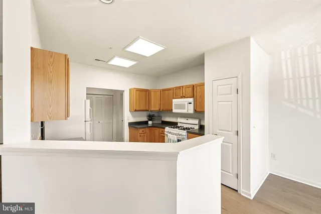 a kitchen with kitchen island a stove a sink a refrigerator with grey walls