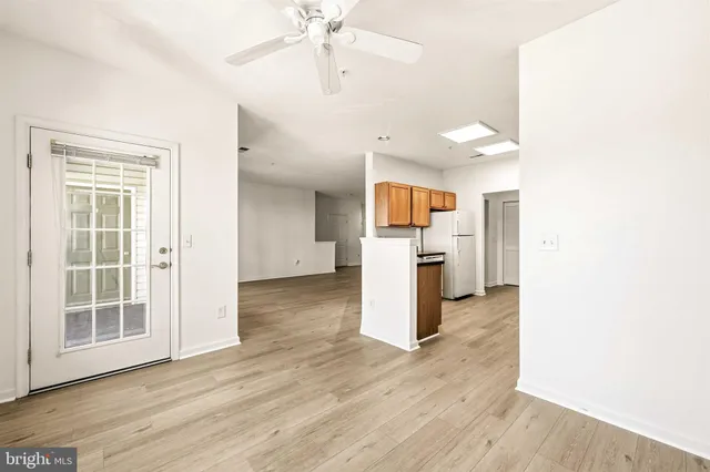 a view of a kitchen with a fridge wooden floor and a window