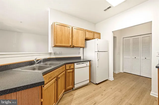 a kitchen with a sink a refrigerator and cabinets
