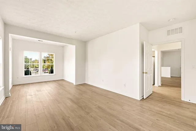 an empty room with wooden floor and a window