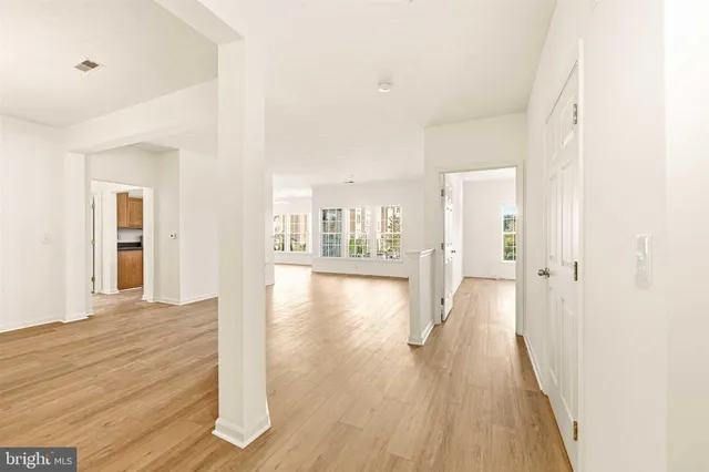 a view of a hallway with wooden floor and windows