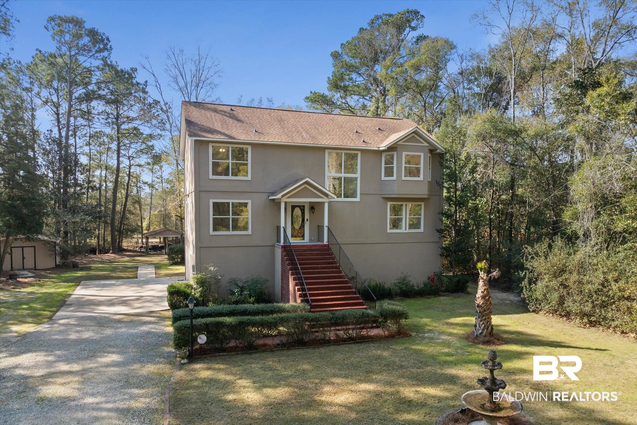 3847 Riviere Du Chien Road Mobile, AL 36693 - Photo 34 of 51 View of front facade with concrete driveway, a front lawn, a shingled roof, a storage unit, and stucco siding
