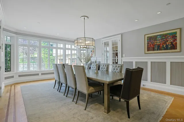 a view of a dining room with furniture large windows and wooden floor