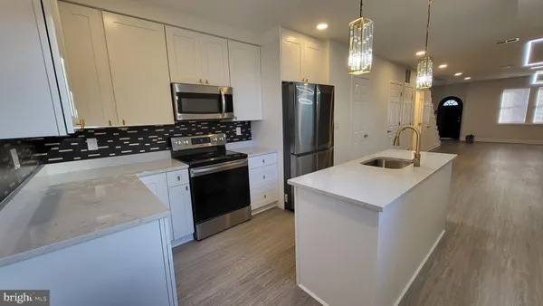 a kitchen with a sink a microwave a stove and refrigerator